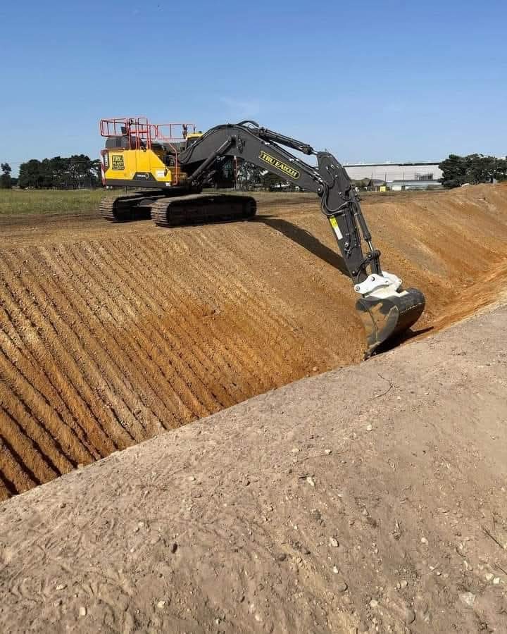 Excavadora perfilando un corte de terreno